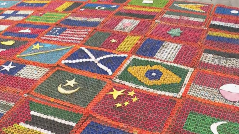 Artista utiliza tampinhas de garrafas PET para criar bandeiras dos países que jogam a Copa do Mundo
