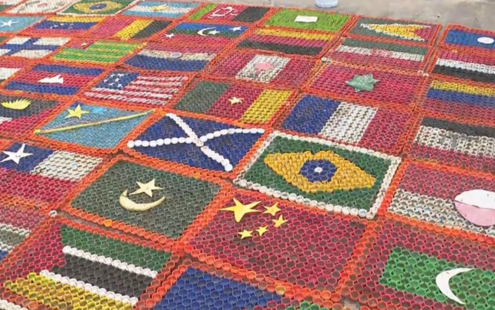 Artista utiliza tampinhas de garrafas PET para criar bandeiras dos países que jogam a Copa do Mundo